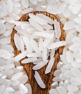 Rice grains on a wooden spoon