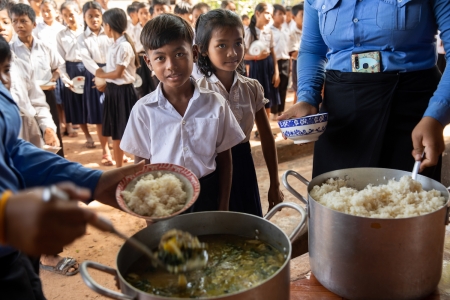 Children at school in Cambodia line up for school lunch