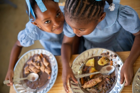 School girls enjoying nutritious school meal with local vegetables