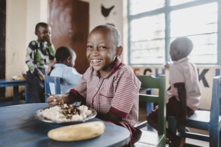 A student eats their school lunch at EP Bwama School in Nyamagabe District