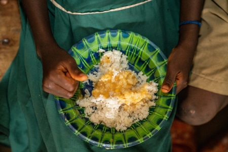 A hot meal of rice with vegetable sauce is provided to students at KDC Primary School in Dar Es Salaam Community, Sierra Leone