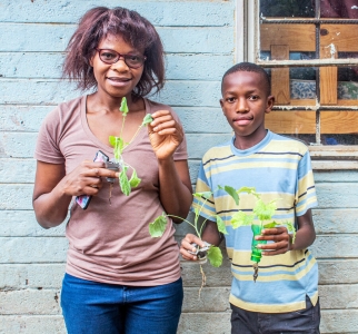 David and his mother Diana with rapeseed leaves growing in recycled plastic bottles at their home in Kitwe