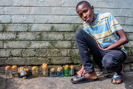 David growing crops in recycled plastic bottles at his home in Kitwe